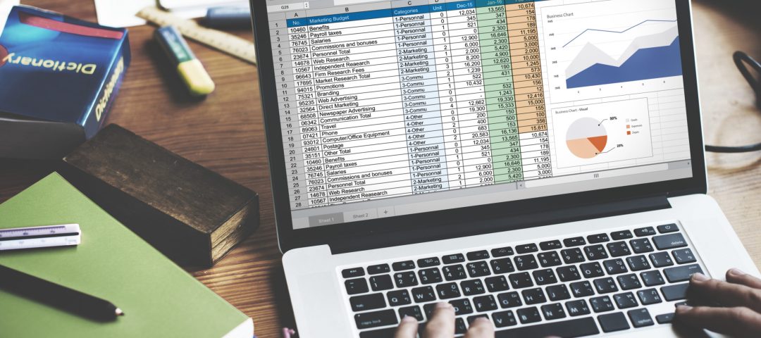 Closeup of hands using computer laptop with screen showing analysis data